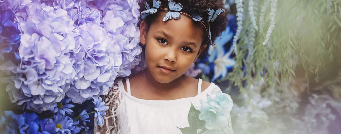 portrait photography of little girl among silk flowers for michael's challenge photo project by Brenda De Los Santos