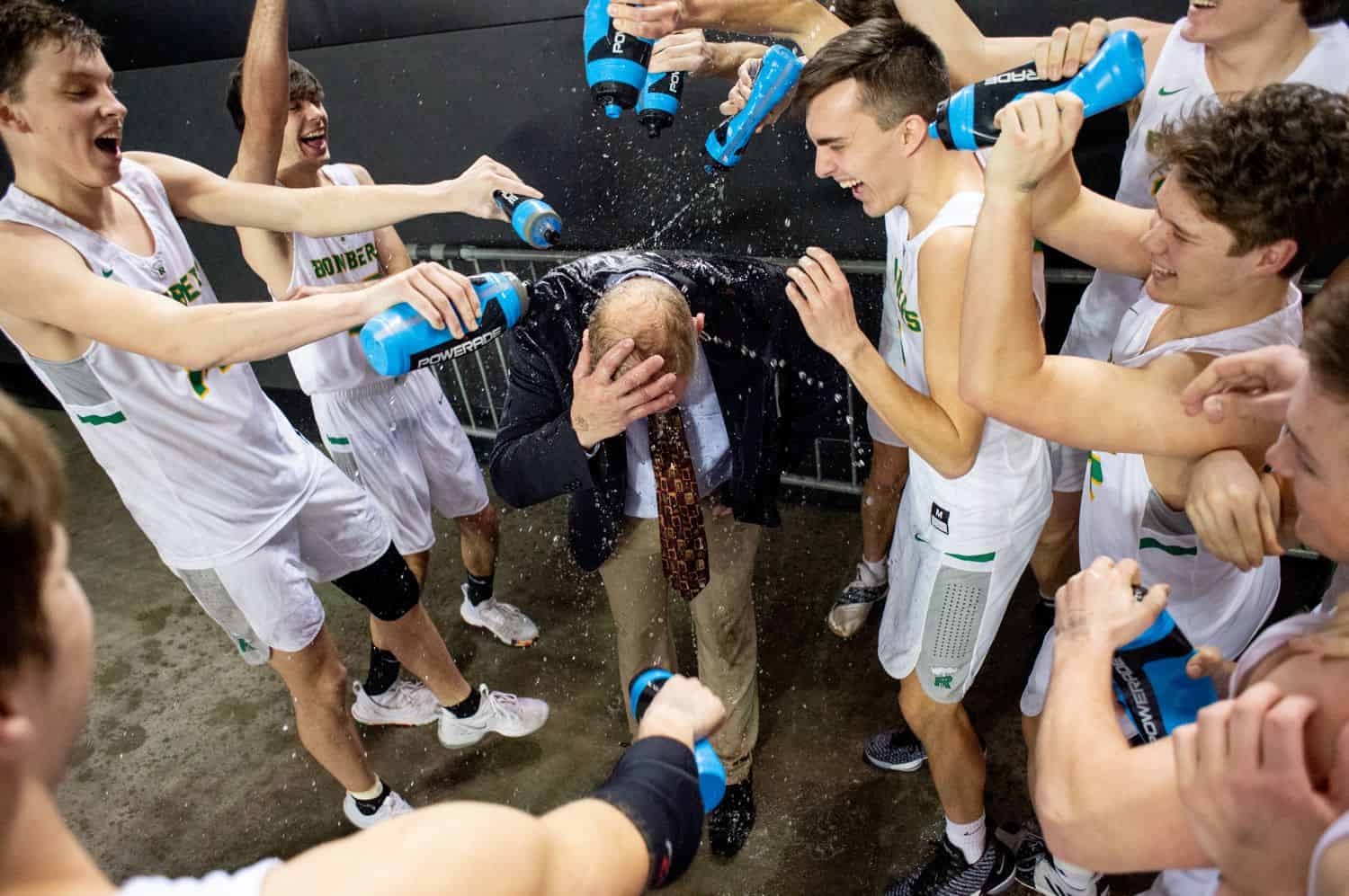 A boys high school basketball team drenches their coach in Gatorade after a big win