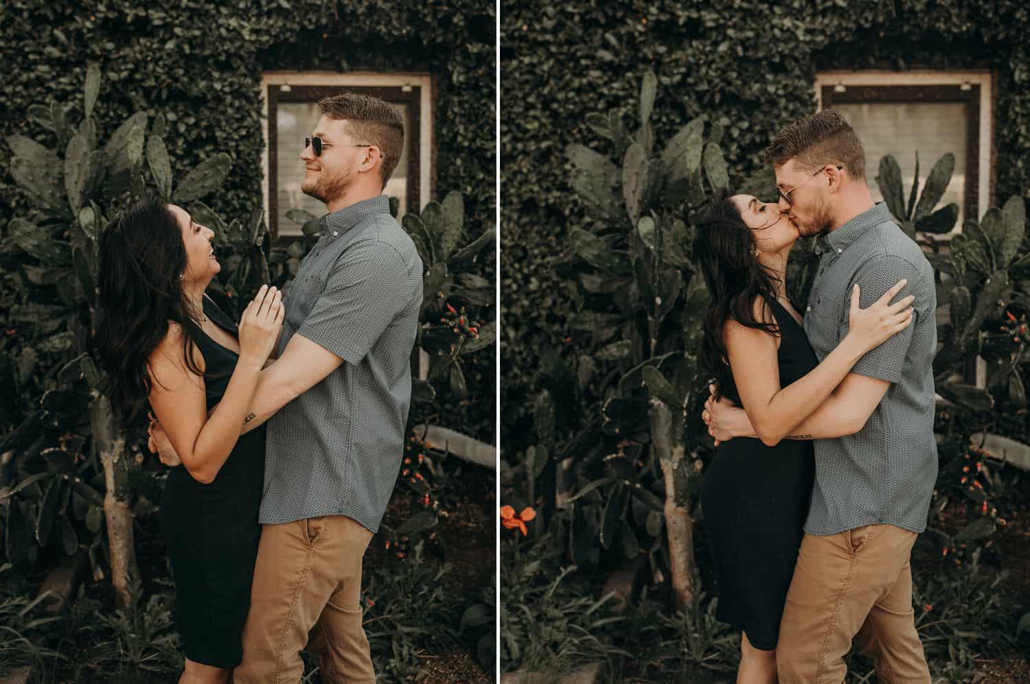 A couple embraces in the shade of a beautiful old building