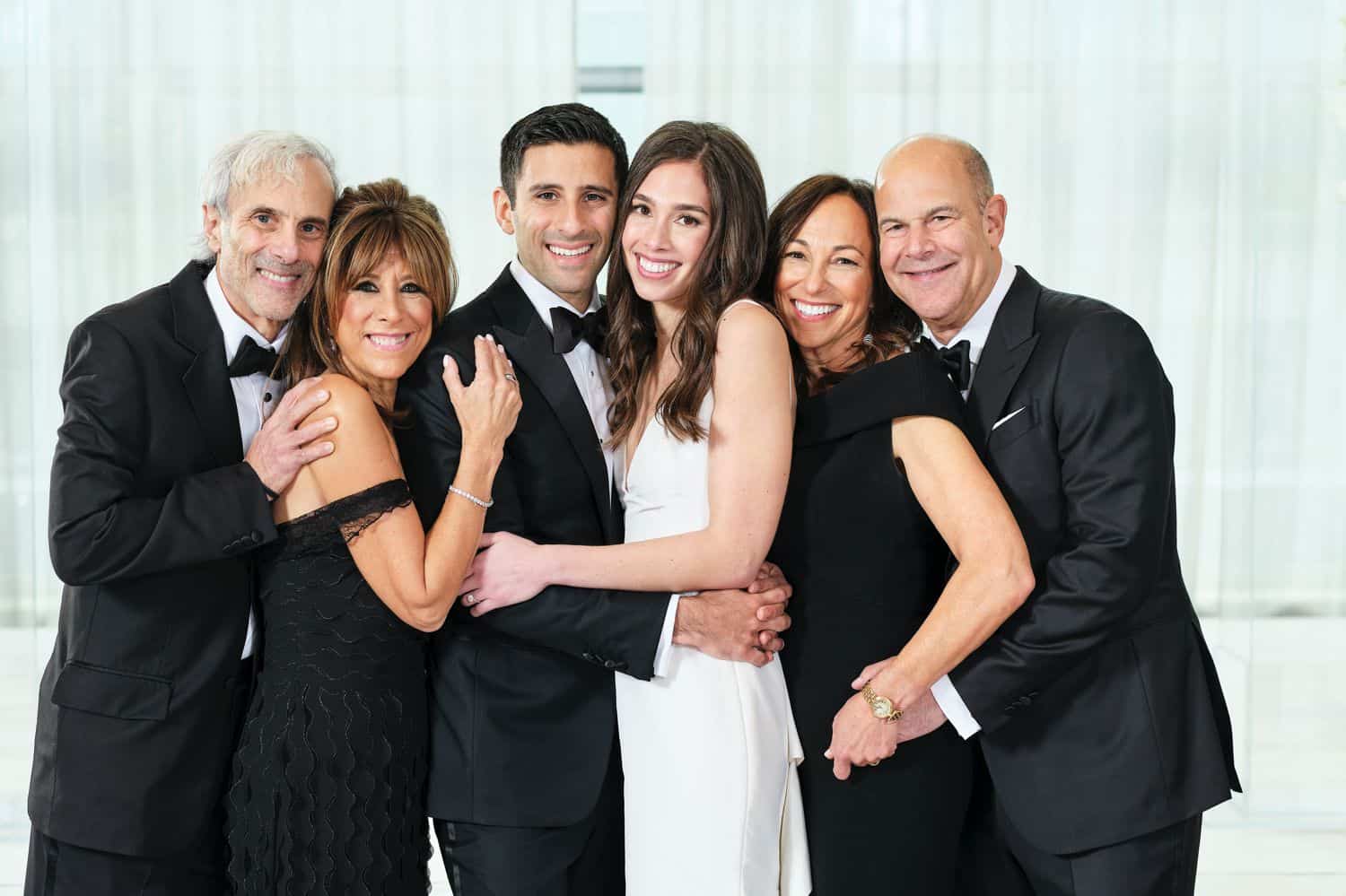 Family hugs close for a portrait at a wedding