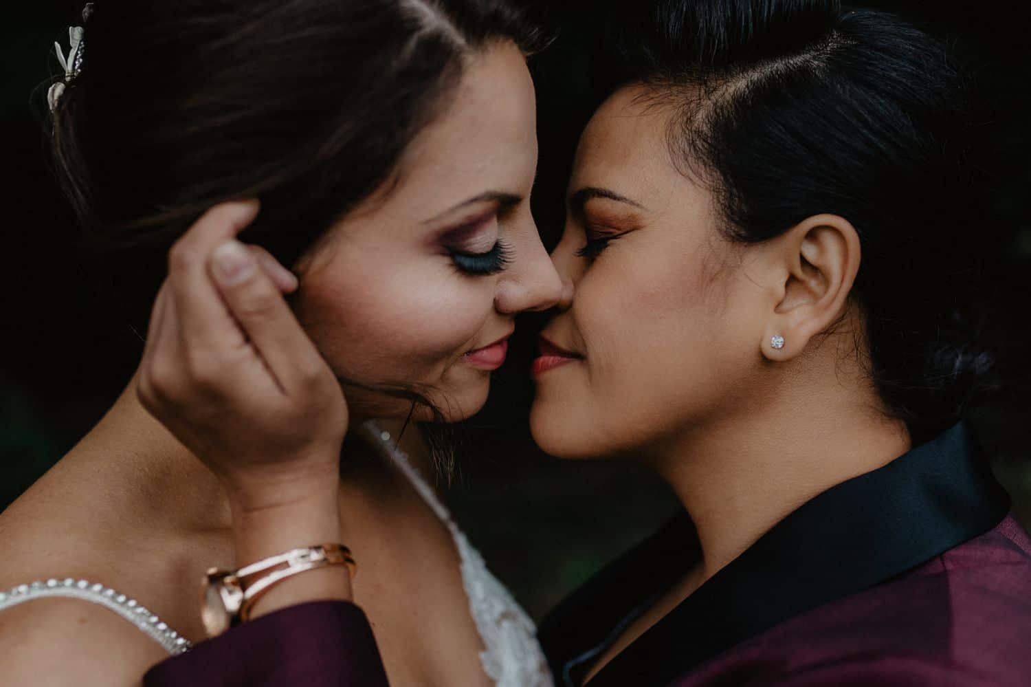 Two women move close for a kiss on their wedding day