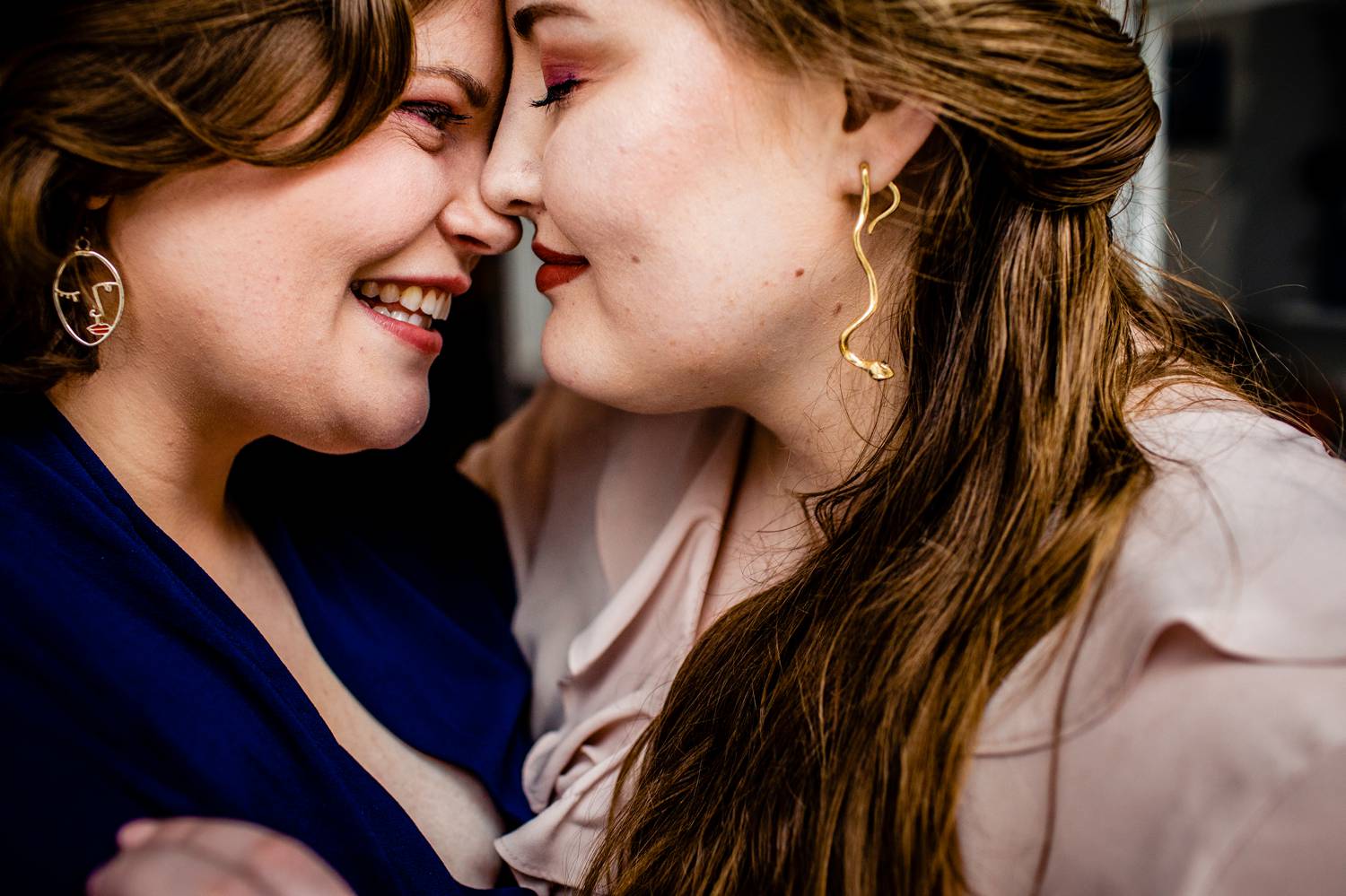 Two women move in to kiss in this close-up photograph from their engagement session