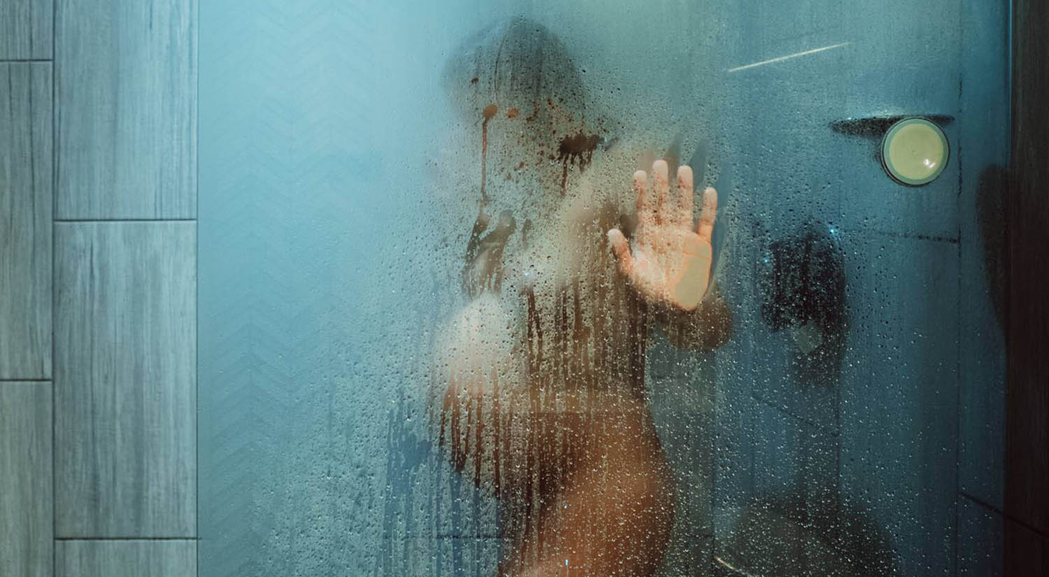 A pregnant woman's outline is seen through a foggy show door