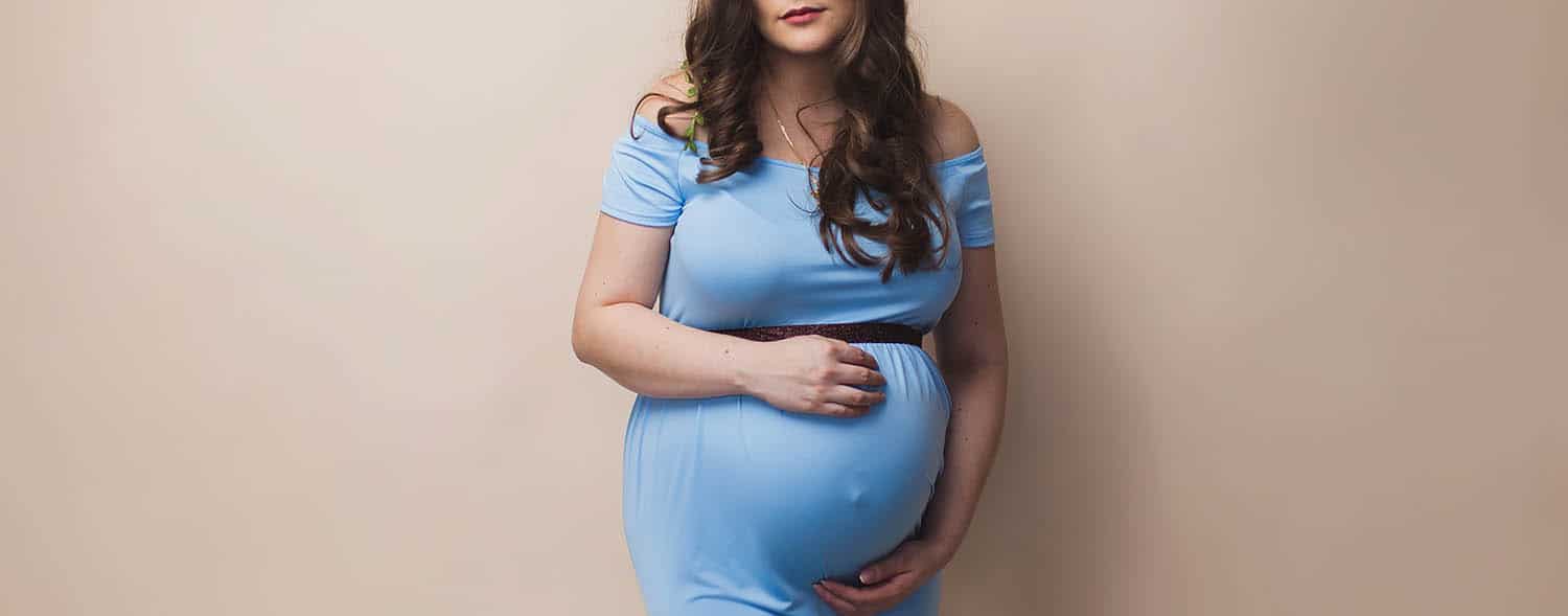 A pregnant woman in a blue dress