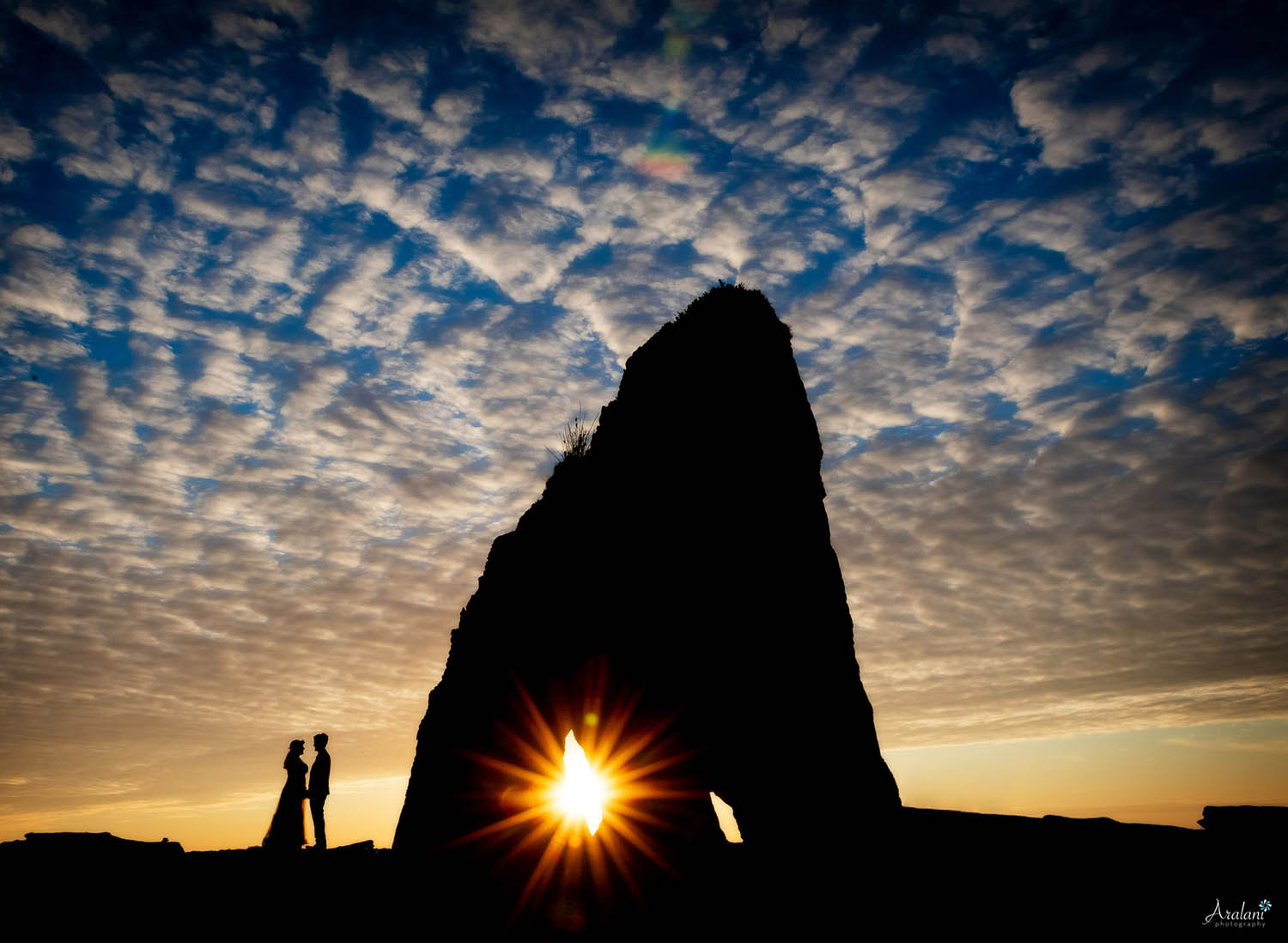 Silhouette of a wedding couple on an Oregon beach at sunset (by Ara Roselani)