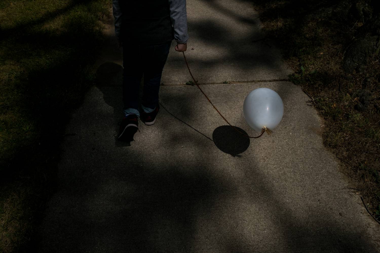 A child walking holding a balloon (Photo by Kirsten Lewis)