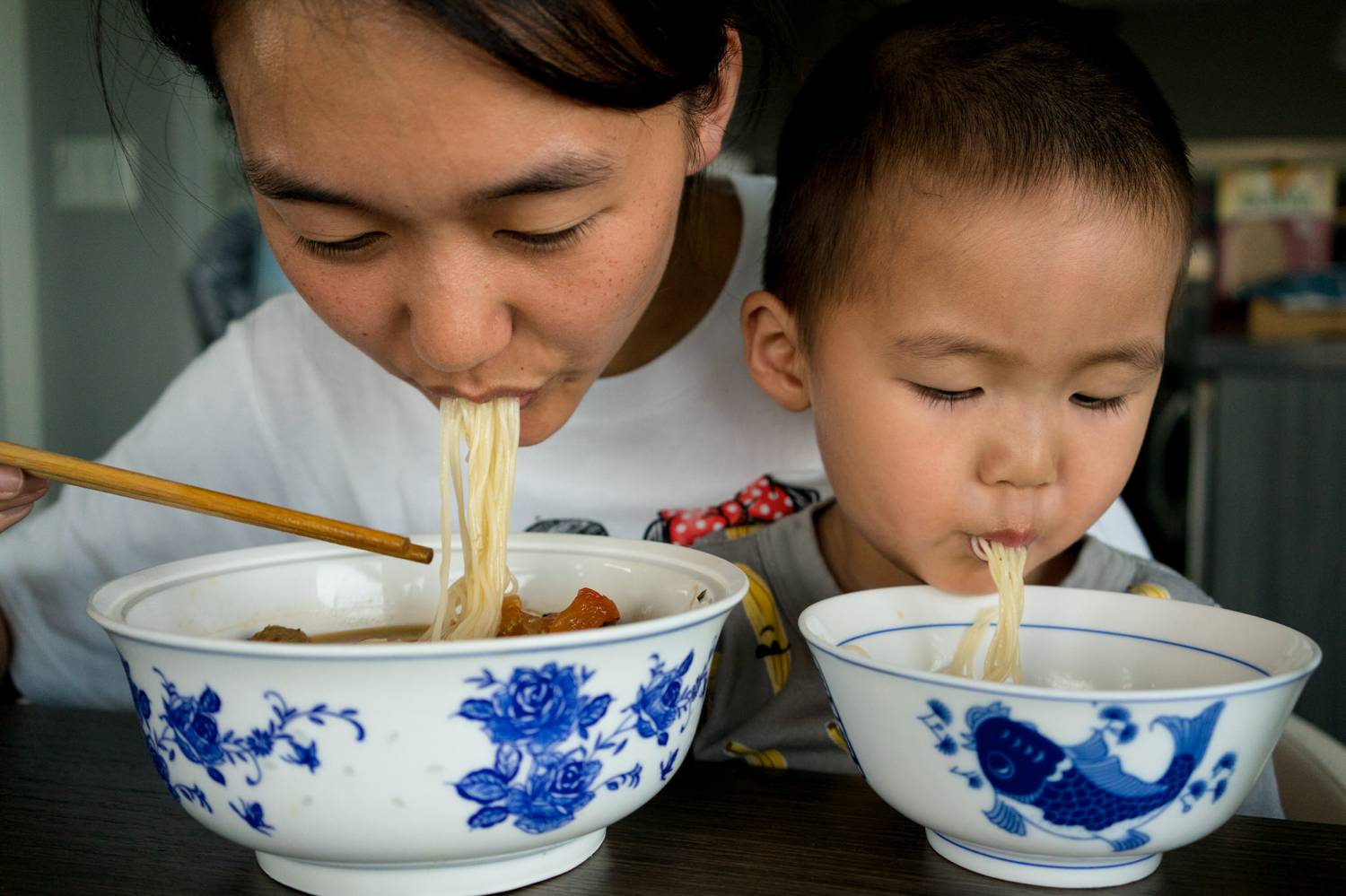 Asian mother and son eating noodles. (Photo by Kirsten Lewis)