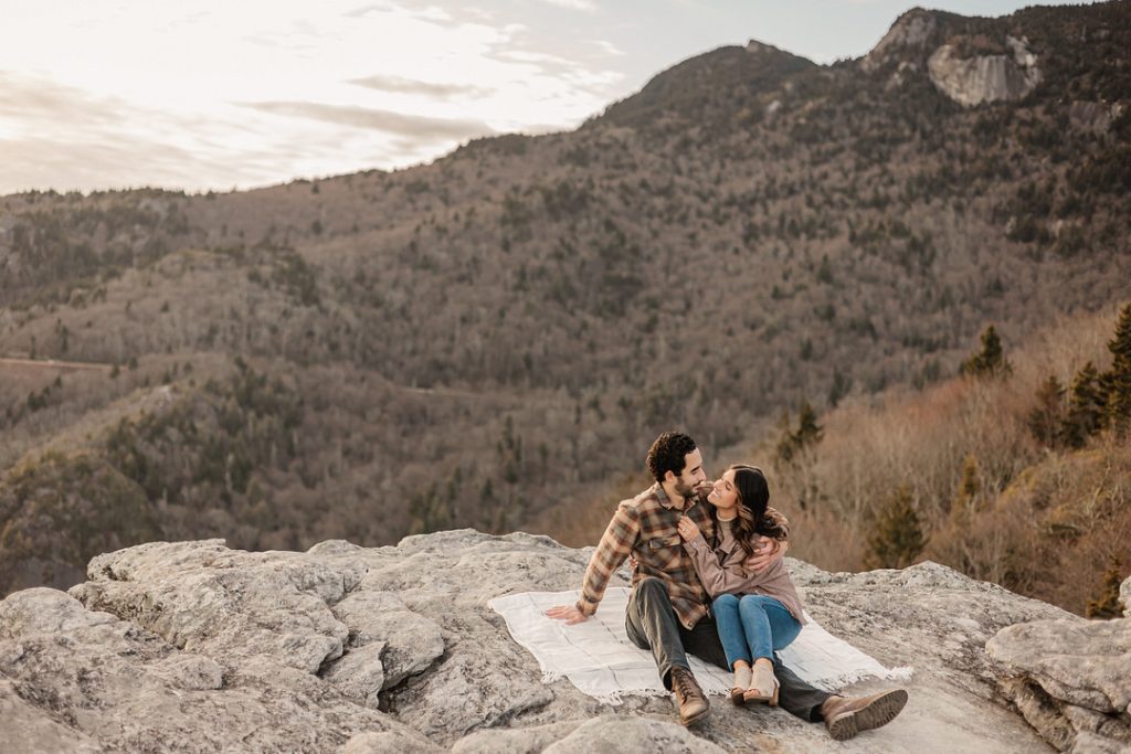 Engagement photograph of couple sitting on a rock