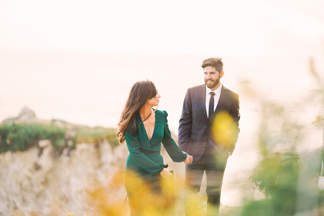 Engagement photo of couple walking in a field