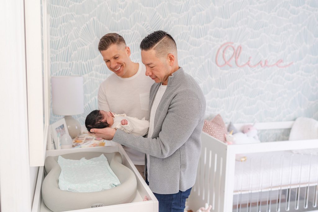 couple over crib with baby