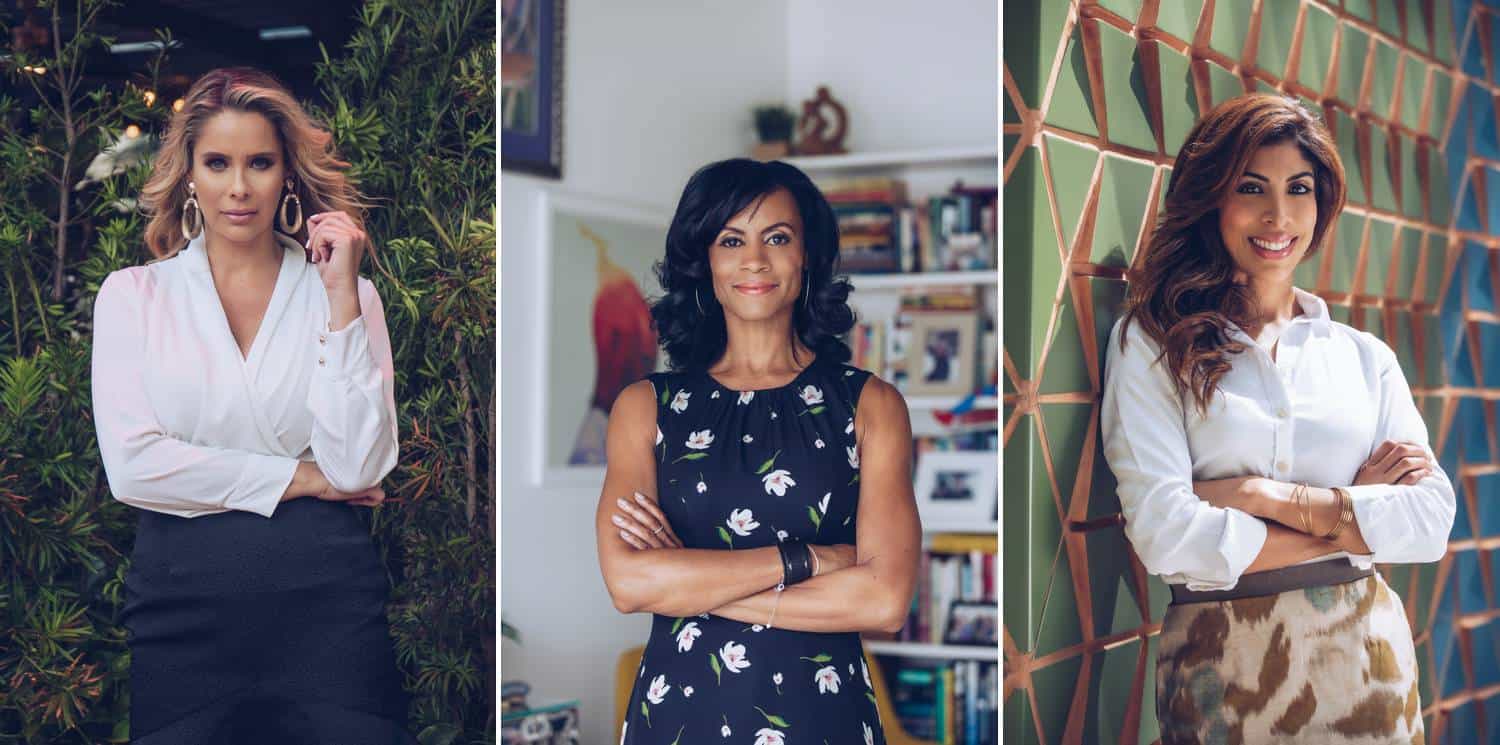 Three photographs made by Lauren Alexis are displayed side by side. In the left portrait, a blonde woman in a white shirt and black pencil skirt stands with one arm folded across her stomach and the other hand reaching up to tease her hair. In the middle portrait, a Latinx woman in a navy floral dress stands in an office with her arms folded. In the right portrait, a brunette woman in a white shirt leans against a color Miami wall.