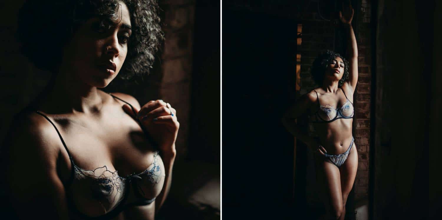 A woman with short curly hair is photographed in lingerie in a dark studio.