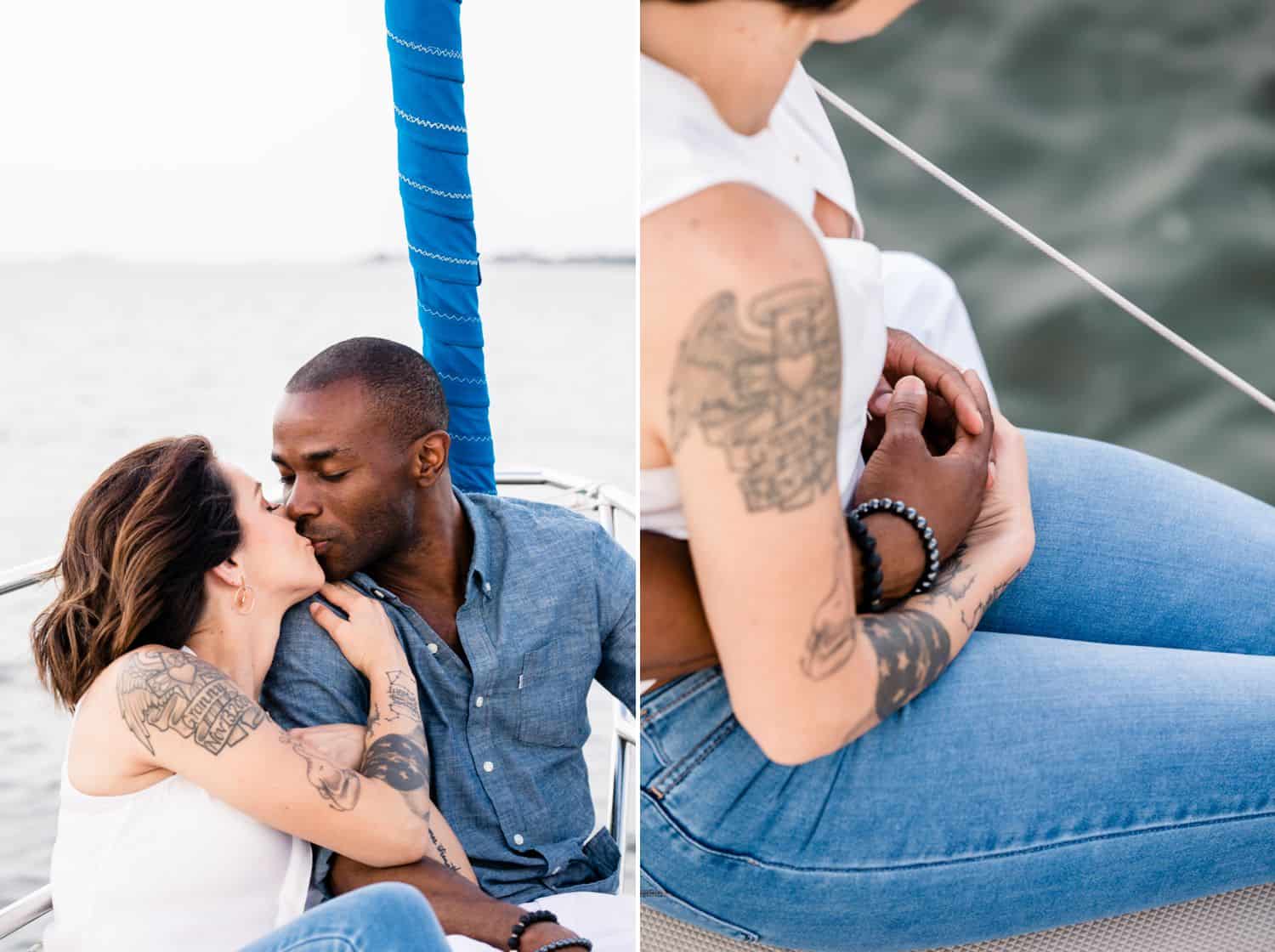 A White woman sits on a sailboat kissing a Black man.